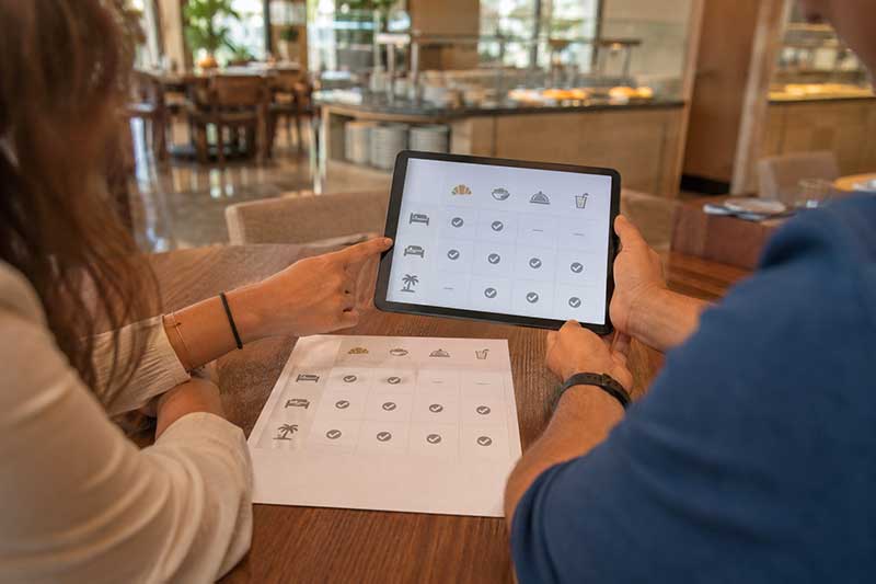 Verifica dei servizi inclusi nel trattamento dell’hotel Viaggiatori che controllano pasti e servizi inclusi nella prenotazione dell’hotel